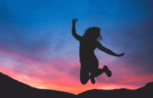 mulher pulando de felicidade após atingir os seus objetivos pessoais